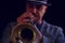A jazz musician plays a silver trumpet