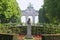 Jean-Baptiste Nicolas Robert Schuman Sculpture in Parc du Cinquantenaire with Triumphal Arch Arcades du cinquantenaire in the ba