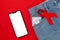 Jeans with a condom in the pocket and a red ribbon. Close up. Red background. Flat lay. Mock up. The concept of world AIDS day and