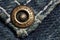 Jeans rivet, old dirty jeans, macro photo. Fashion jeans button. Sign JEANS JEANS on bronze part of button. Blue denim