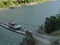 A jeep drives over a rope bridge over a river