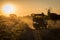 Jeep driving down dusty track at sunset