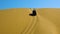A jeep slowly drove down from the top of the dune. Namib Desert.
