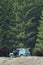 A jeep standing on the cliff edge on a background of the forest