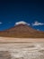 Jeep SUV car transportation vehicle in front of Licancabur cone shape volcano mountain Bolivia Chile Andes South America