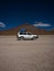 Jeep SUV car transportation vehicle in front of Licancabur cone shape volcano mountain Bolivia Chile Andes South America