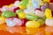 Jelly beans sweets candy piled on an orange background. High sugar unhealthy food concept