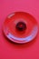 jelly dessert in a red round plate on a bright red background . A gelatinous dietary low calorie vegetarian dessert