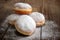 Jelly doughnuts with powdered sugar on wooden background