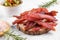 Jerky meat strips with spices, olives, snack for beer on wooden plate, close up