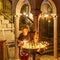 JERUSALEM, ISRAEL - April 2, 2018: woman sets candles in the Church of the Holy Sepulchre.