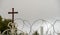 Jerusalem, Israel - cross and a chain fence and barbed wire.