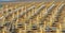 Jesolo, Italy. Beach umbrellas and sun beds at Italian sandy beach. Raws of Yellow and white umbrellas. Aerial view at sunrise