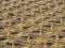 Jesolo, Italy. Beach umbrellas and sun beds at Italian sandy beach. Raws of Yellow and white umbrellas. Aerial view at sunrise