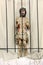 Jesus behind bars in prison. Wooden figure of Jesus in the church during Easter.