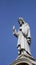 Jesus Christ statue atop a church with blue sky in the background - Savior concept.