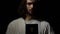 Jesus in crown of thorns holding bible near heart, faith and belief concept