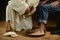 Jesus Washing Feet of Man in Jeans