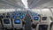Jet airplane interior view economy class monitors on seats