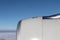 Jet engine aircraft. Blue sky and white clouds below.