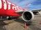 Jet engine generate thrust under the wing of Thai Airasia, Airbus A320 airplane parked on the parking lot.