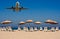 Jet flying over sunloungers on empty beach