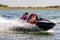 Jet ski watercraft driver with woman on back seat in action on summer sunny day