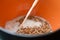 A jet of white milk is poured into a deep bowl of buckwheat.