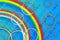 Jets of rain cross the rainbow, and colored circles at an angle against a blue background. Abstract background