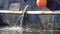 Jets of water from the holes in the blue Board of a metal fishing ship. Marine engine cooling system