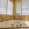 Jetted bathtub inside a sunlit bathroom