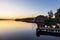 Jetty, boathouse and sailboats at the lake Schaalsee during sunrise in Seedorf, Germany