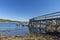 Jetty in ebb tide in a fjord in Norway with boats in background