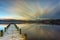 Jetty over Windermere lake with streaking clouds