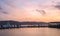 Jetty with people and sailboat silhouette during sunset