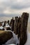 Jetty Pillars and Rocks Covered witn Snow in a Cloudy Winter Day
