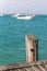 A jetty pylon with selectively blurred fishing boats located in Beachport South Australia on February 18th 2022