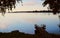 A jetty reflected in the still water at sunset, wet footprints on the jetty