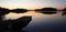 A jetty reflected in the still water at sunset, wet footprints on the jetty