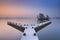 Jetty on a still lake on a foggy winter\'s morning