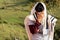 Jew wearing tallit and Tefillin or Phylactery praying in nature while covering his face with his hands.