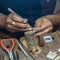 Jeweler making handmade jewelry on vintage workbench.