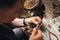A jeweler removes details from a gold ring with precious stones in a workshop