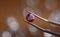 Jeweler in workshop holds pink stone in tweezers