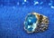 Jewelery ring with gem aquamarine on blue background