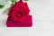 Jewelry gift box and bautiful red rose on wooden background