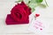 Jewelry gift box and bautiful red rose on wooden background. Greeting card for Mother`s day