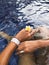 Jewelry hand model wearing silver rings and bracelet holding a flower