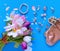 Jewelry women accessories white pearl rings and earrings with tulip Bouquet pink and gold cosmetic case on blue background, costum