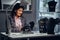 Jewelry worker dressed in elegant clothes sitting at work table and make examine of necklace in a jewelry store.